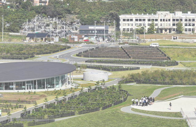 東日本大震災 震災伝承活動のイメージ写真(写真提供:3.11メモリアルネットワーク/「語り部とあるく3.11」プログラムより。写真内左の建物は宮城県石巻市・みやぎ東日本大震災津波伝承館、右奥に震災遺構)。石巻から始まり、被災3県をつなぐ広域連携を視野に立ち上がった「3.11メモリアルネットワーク」の震災伝承を支える活動は、「災害で命が失われない社会の実現」に向け、課題の共有、防災・減災活動の活性化をめざしている